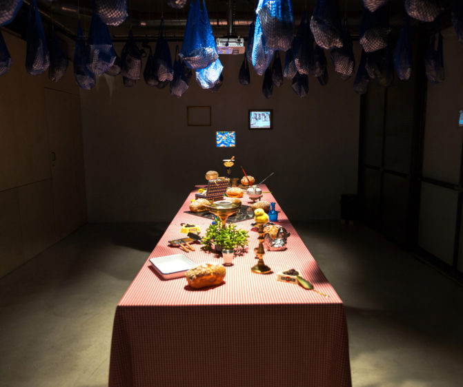 Scénographie soirée inauguration Antoinette pain et brioche vue générale avec mise en scène de la table et suspension de sac filet bleu et projection vidéo